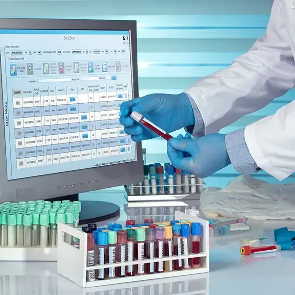 SCC laboratory software on screen beside blood sample tubes
